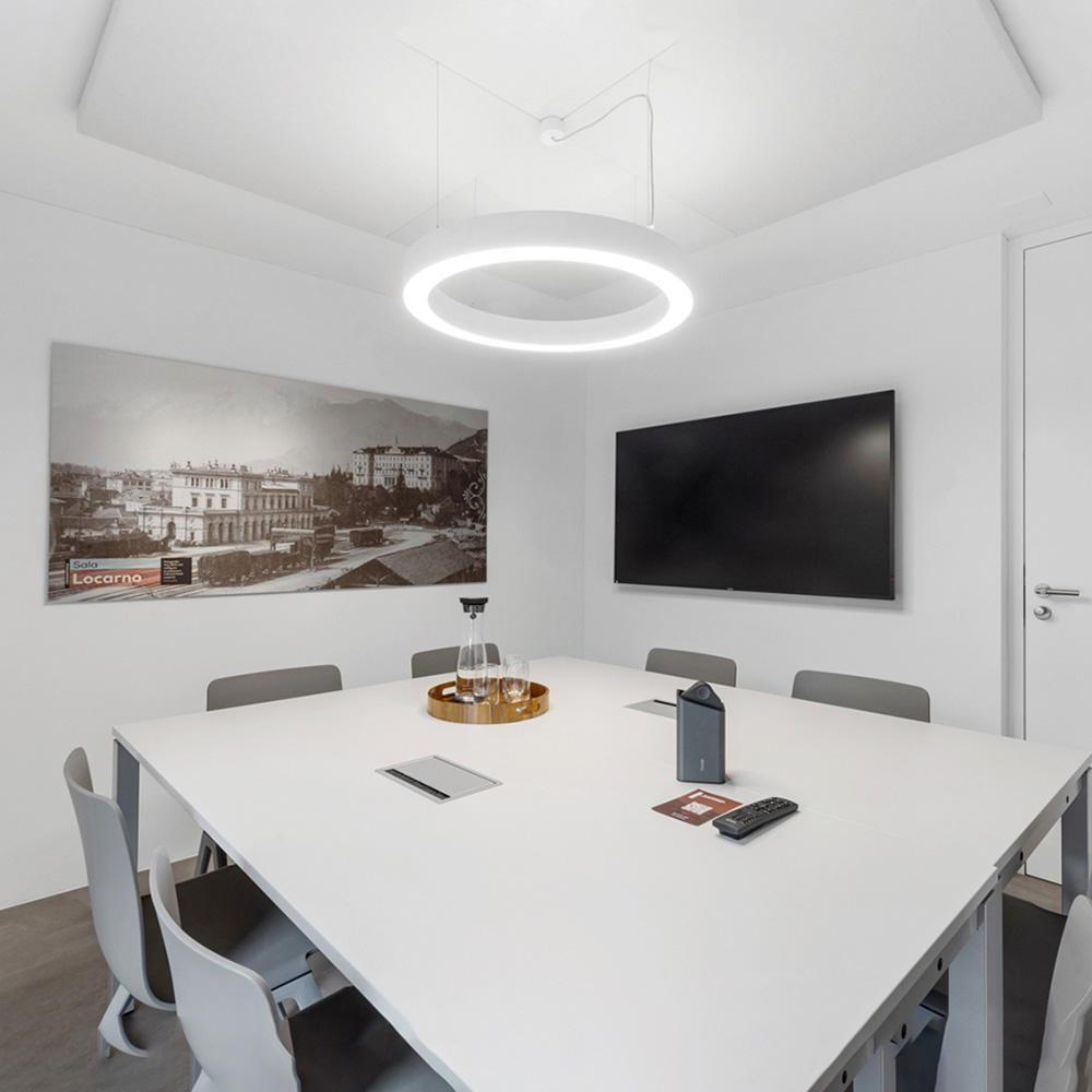 Bureau & espaces de travail 22 Panneaux de plafond acoustiques blancs avec une suspension annulaire au-dessus d'une table de conférence blanche dans une petite salle de réunion élégante