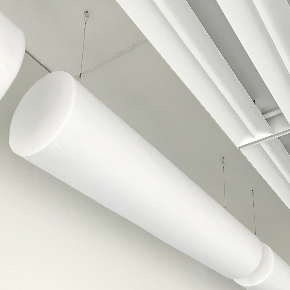 acouFoam Zylinderabsorber 2 Weisser zylinderförmiger Schaumstoffabsorber an Drahtseil von heller Decke mit Lüftungskanälen abgehängt
