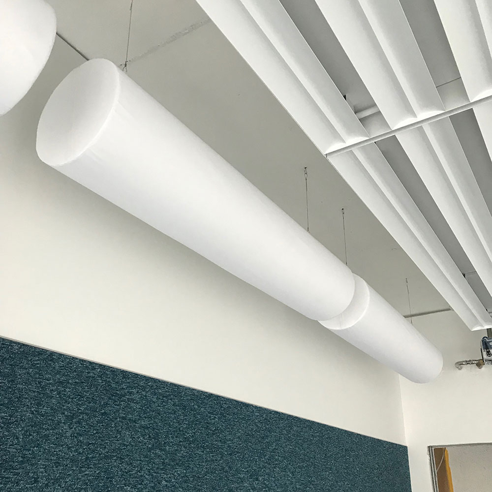 acouFoam Zylinderabsorber 12 Zylinderabsorber mit weissem Stoffbezug in Werkhalle Kanton Zürich zur Reduktion von Nachhall