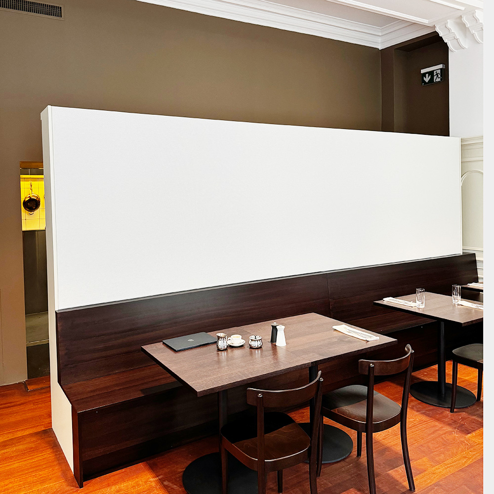 Ristorazione & settore alberghiero 18 Un grande arazzo bianco dietro una panca di legno scuro, in un elegante bistrot con il soffitto decorato con stucchi