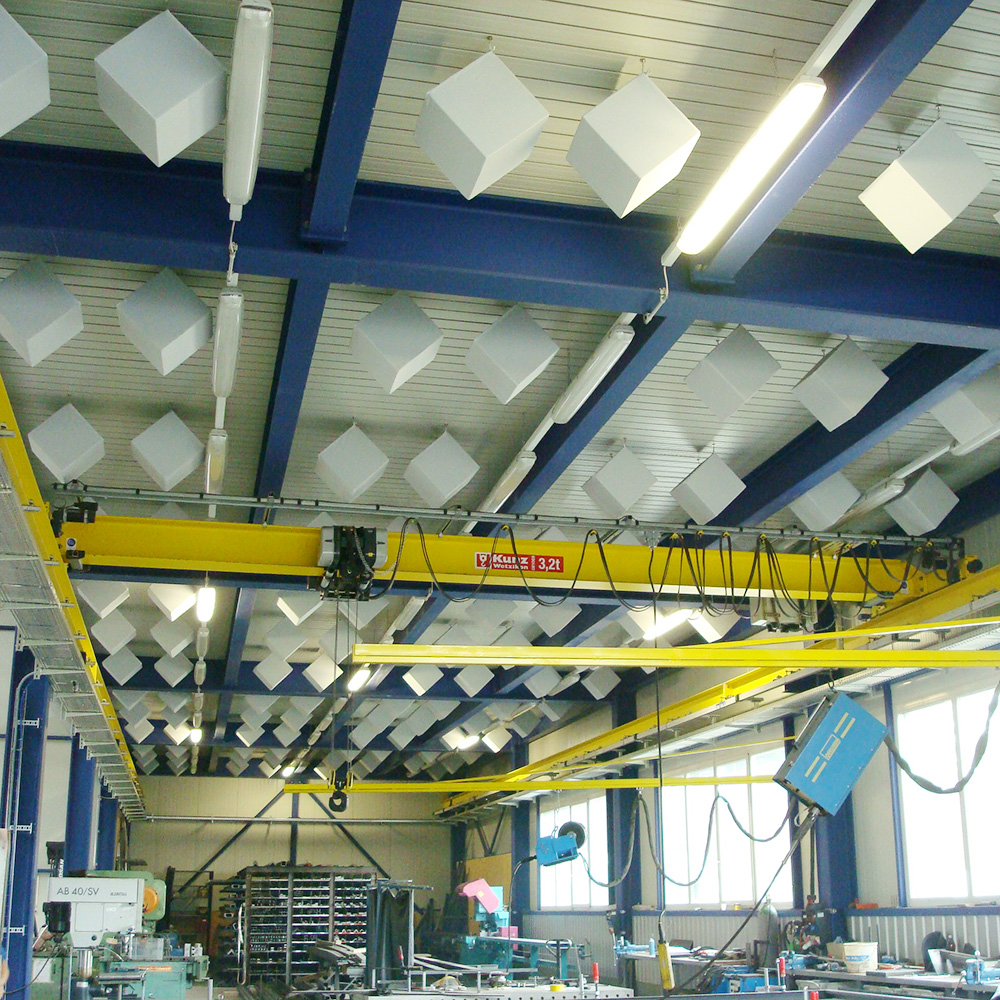 Industrie & Gewerbe 17 Viele weisse Würfelabsorber frei abgehängt unter Hallendecke mit gelben Hallenkranen und blauen Stahlträgern in Maschinenhalle