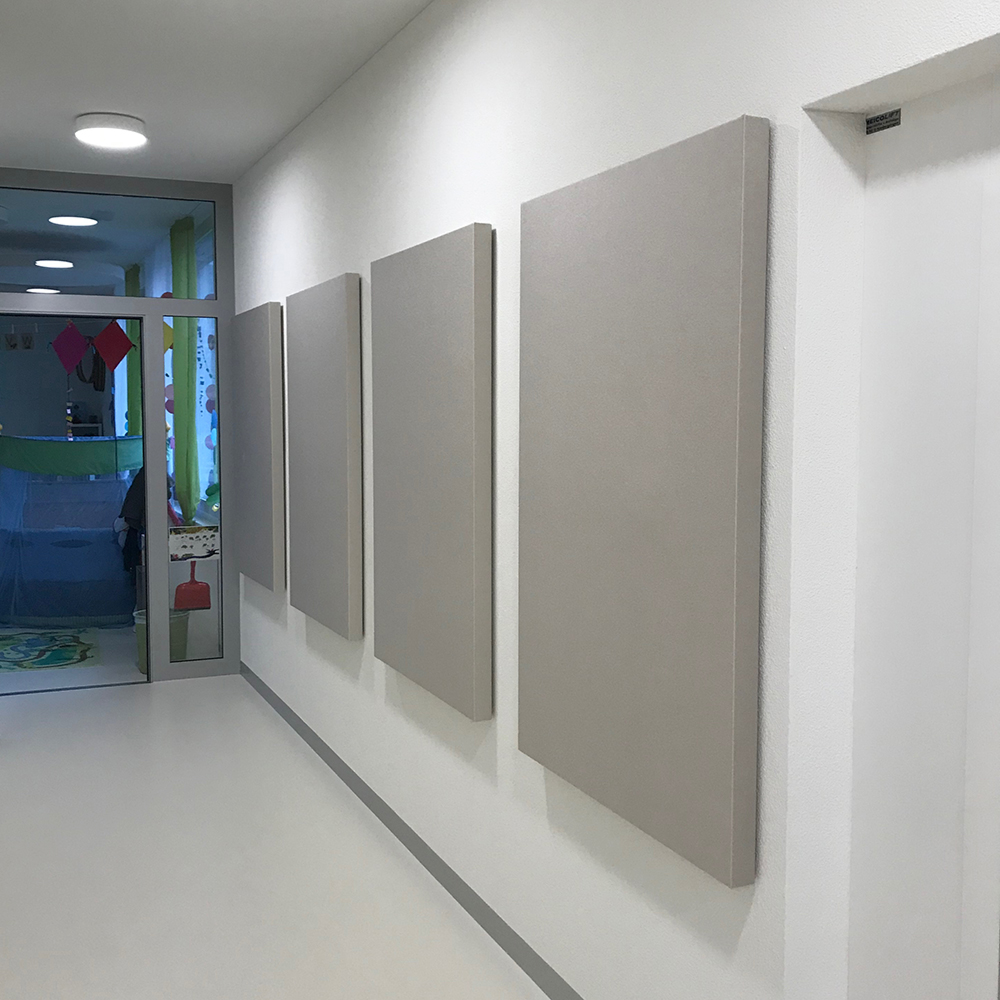 Protection contre l'incendie dans l'acoustique des salles. 17 Trois panneaux acoustiques gris clair ininflammables servant d'absorbeurs muraux dans un couloir d'école lumineux