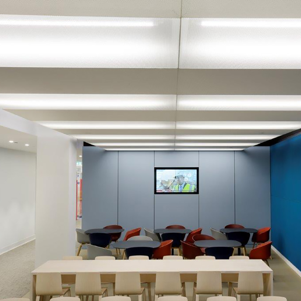 Pannelli per soffitto STRATO raggruppati 5 Panneaux acoustiques blancs allongés avec bandes lumineuses LED intégrées dans une salle de formation moderne