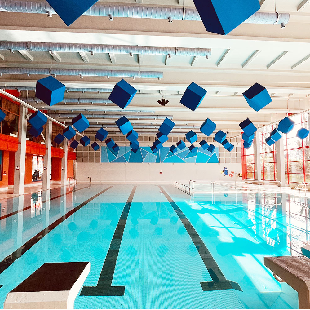 Assorbitori cubici acouFoam 4 Assorbitori cubici blu reale installati a sospensione in una piscina del cantone di Argovia per ridurre il riverbero nella piscina coperta