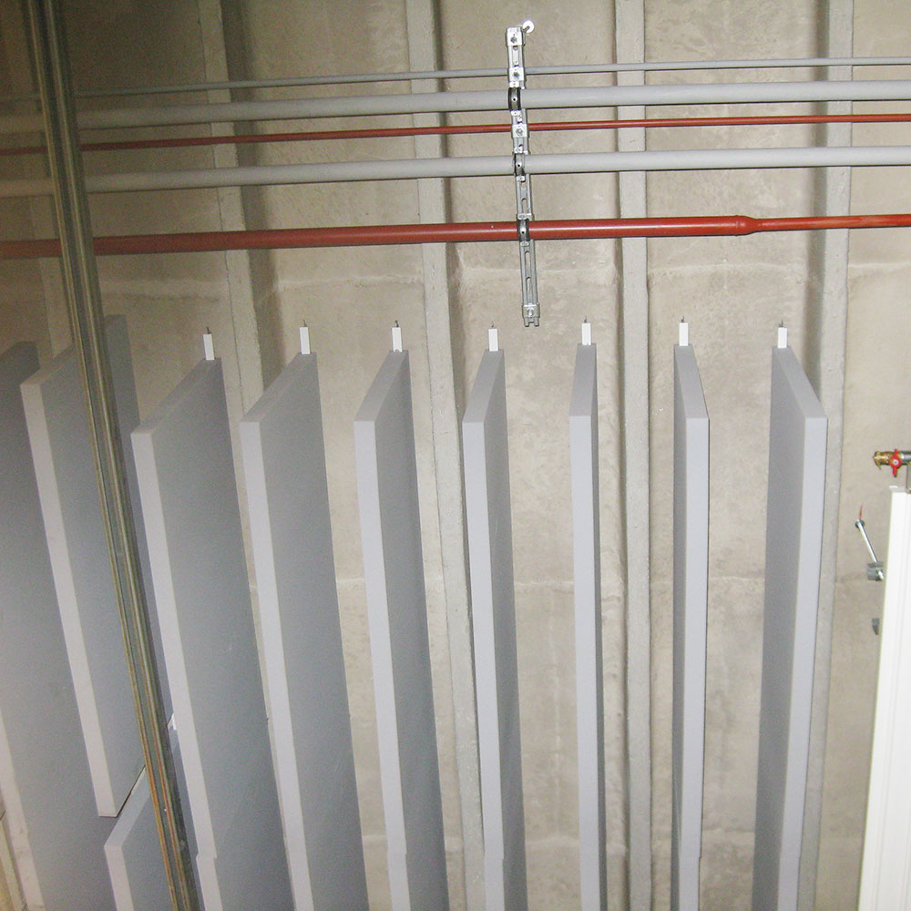 Deflettori acustici acouFoam 11 Vista dettagliata dei deflettori acustici sospesi, dotati di un sistema di fissaggio, in un'officina del cantone di Vaud, destinati alla riduzione del rumore industriale